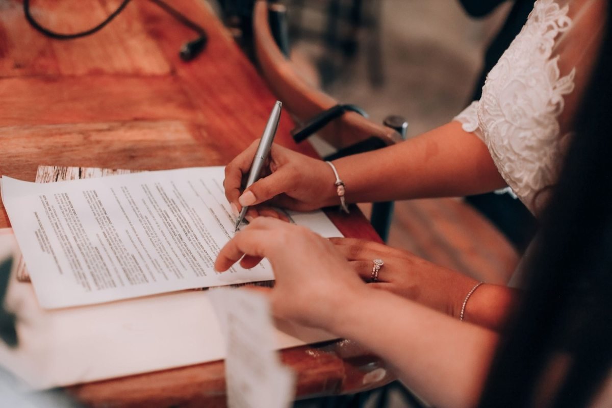 Mains écrivant sur un document à une table en bois Mains écrivant sur un document à une table en bois
