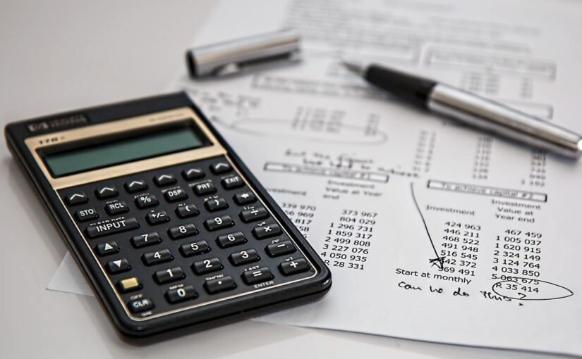 Calculatrice et stylo sur feuille de calcul avec écriture manuscrite